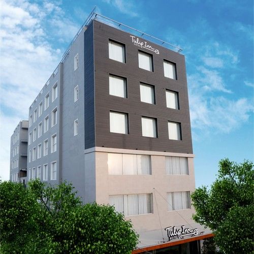 A facade image of TulipInn Zirakpur surrounded by trees in Rishikesh